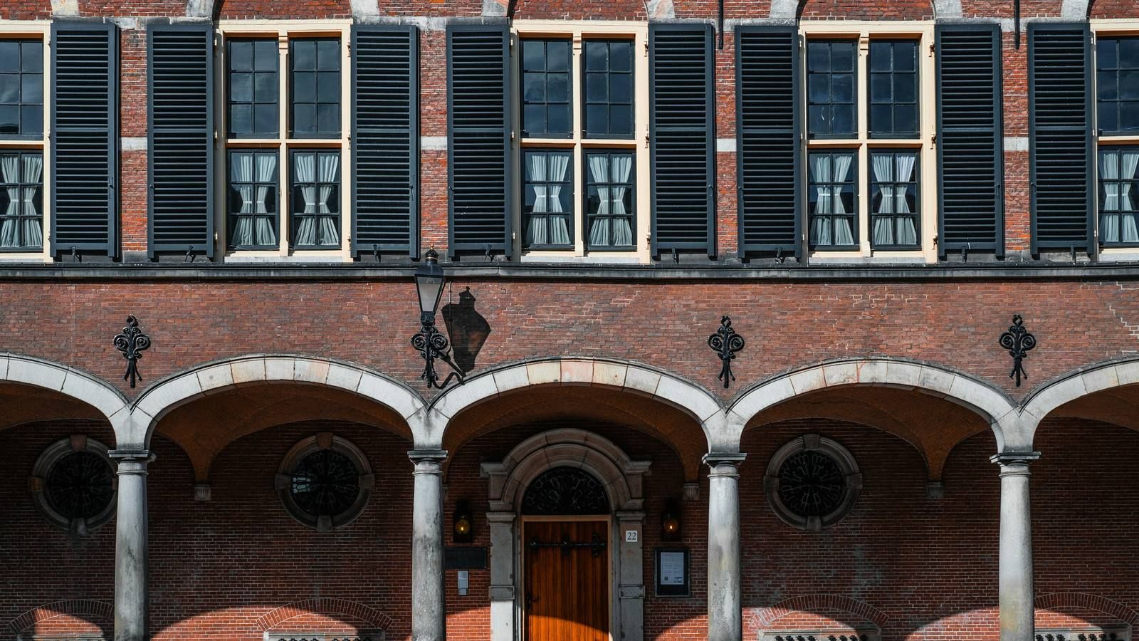 Brick arcade with shutters and a wooden door in The Hague