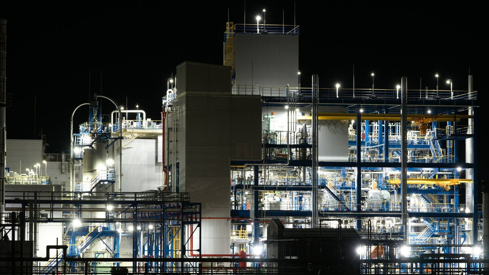 Industrial plant at night under cool blue lighting