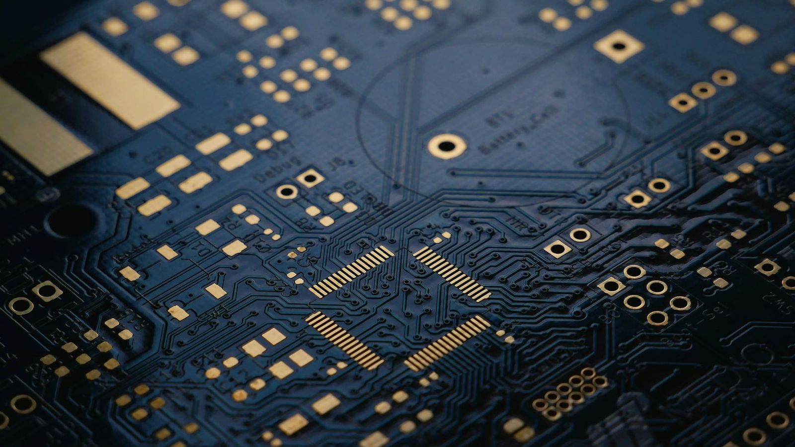 Close-up of a dark circuit board with gold contact pads